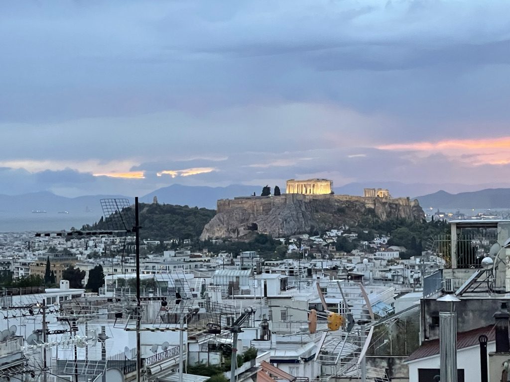 The Acropolis lit at dusk above the rooftops of Athens