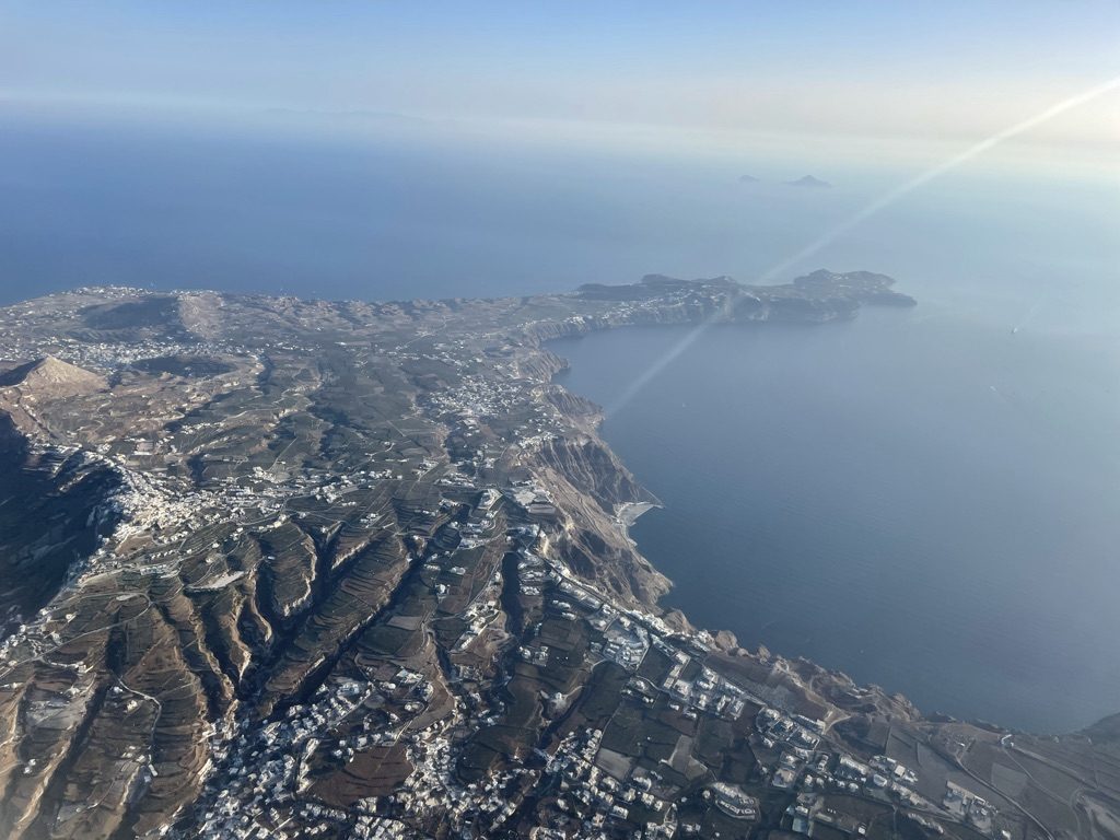 Santorini seen from a plane window, cliffs and villages above the sea